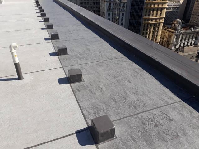 Vista panorâmica da laje de cobertura impermeabilizada com skyline do Rio de Janeiro ao fundo